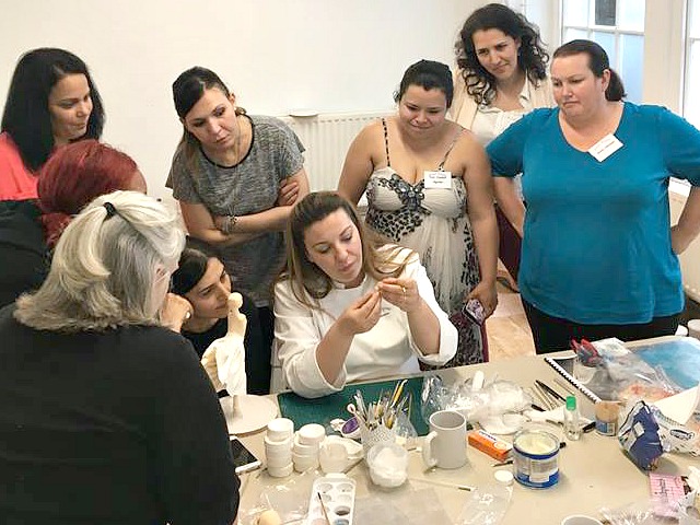 Cake classes with students getting detailed instructons on how to make hands